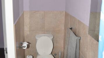 A small bathroom with a toilet, sink, and towel rack.