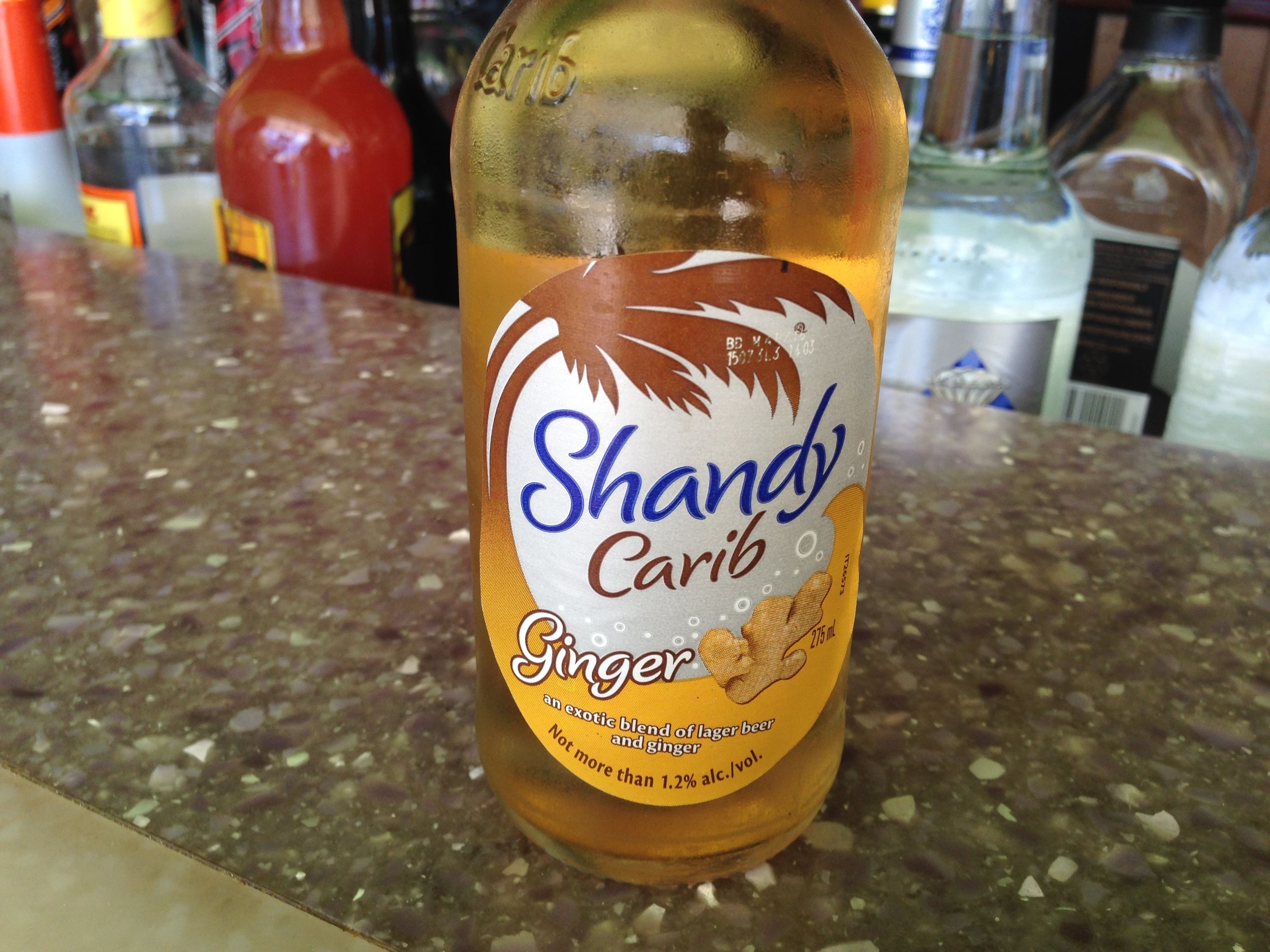 A bottle of Shandy Carib Ginger beer on a countertop.