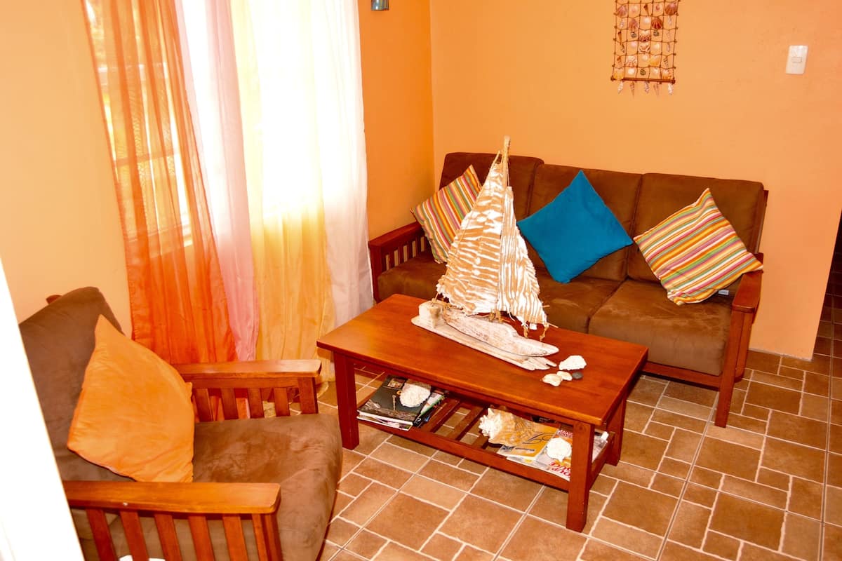 A living room with a brown sofa, a wooden coffee table, and a chair.