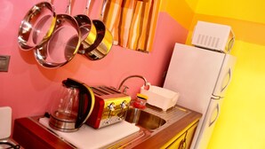 Una cocina con estufa a gas, tostadora, lavamanos y refrigerador.