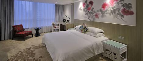 Una habitación de hotel con una cama grande, una mesita de noche, una silla, un escritorio y un ventanal con cortinas.