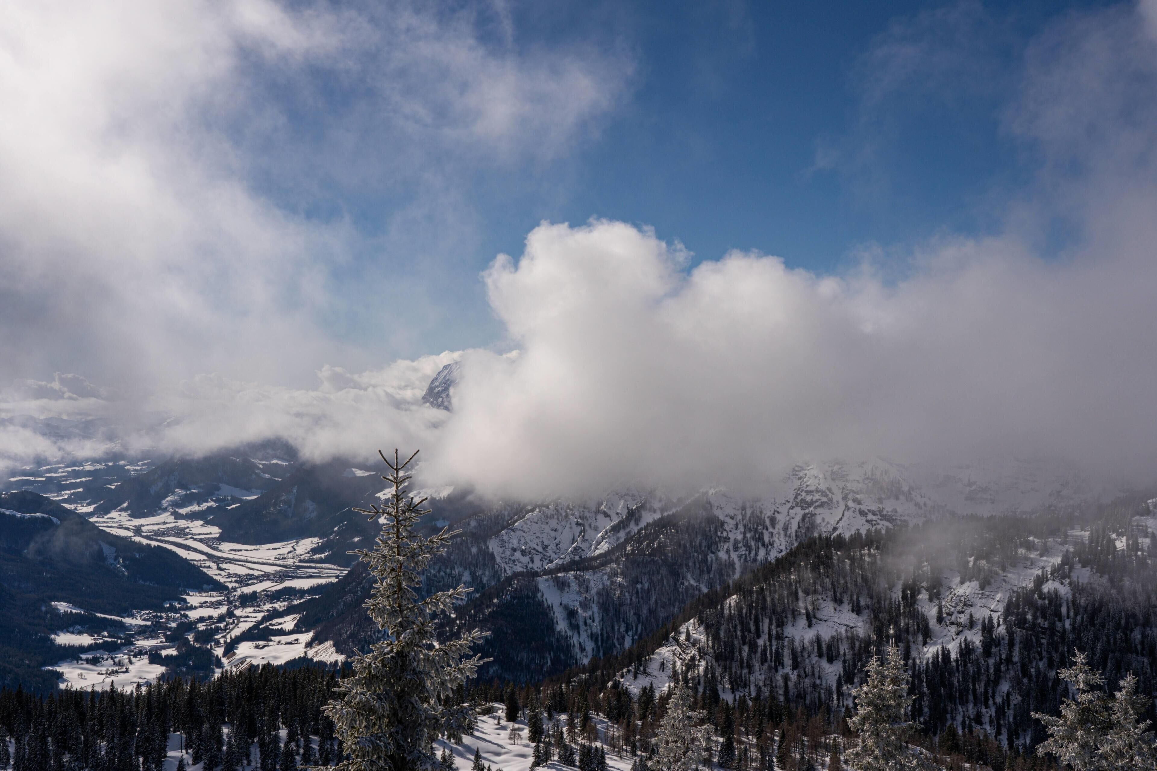 A mountainous landscape with snow-covered peaks and a valley below.