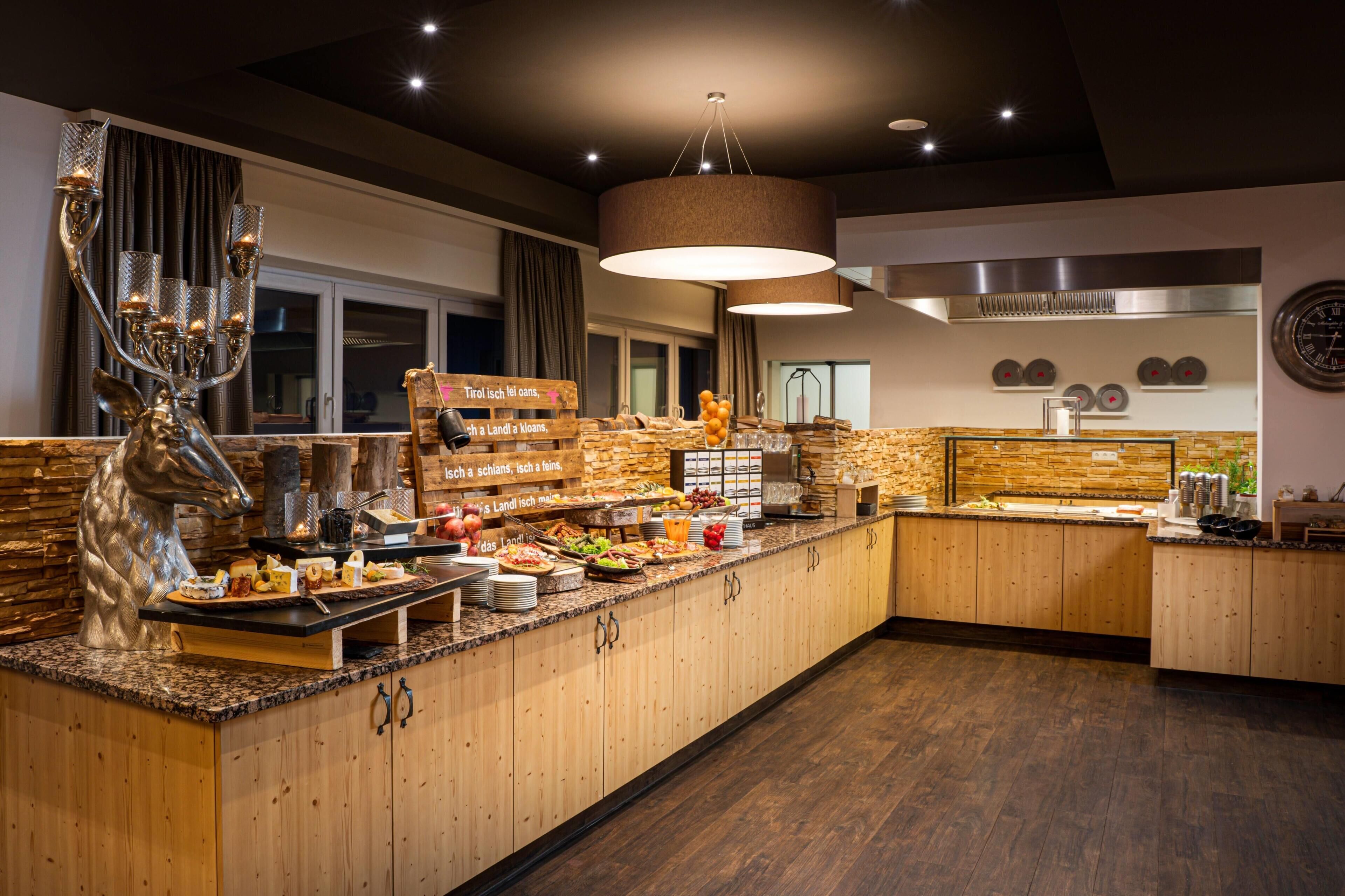 A buffet setup with a variety of food items, a wooden cabinet, and a decorative silver sculpture.