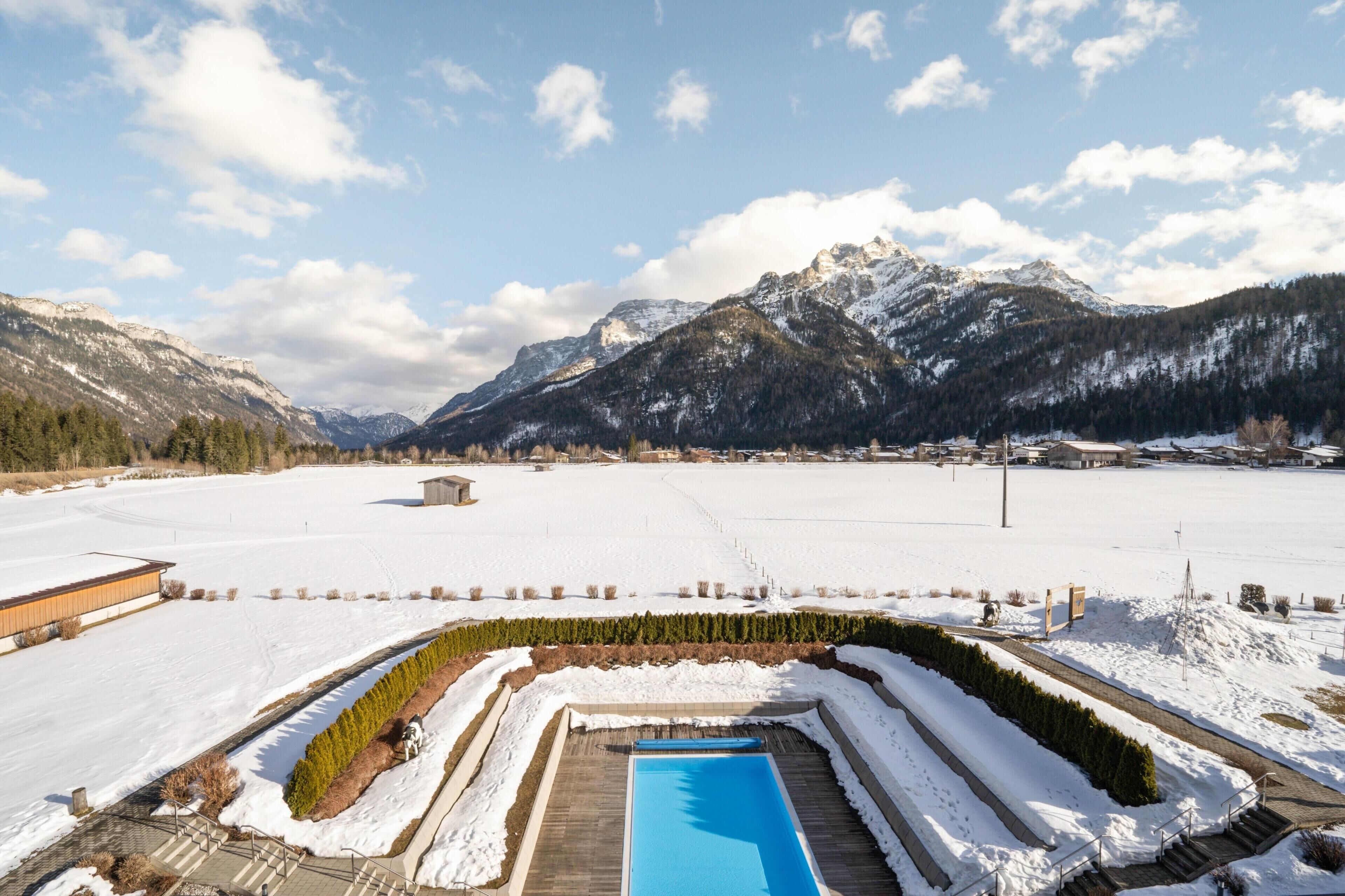 A pool area with a clear view of snow-covered mountains in the background.