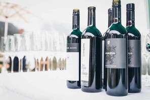 Quatre bouteilles de vin sur une table, avec un arrière-plan flou de verres à vin.