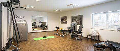 A gym with exercise equipment, a mirror, and a window with a view.