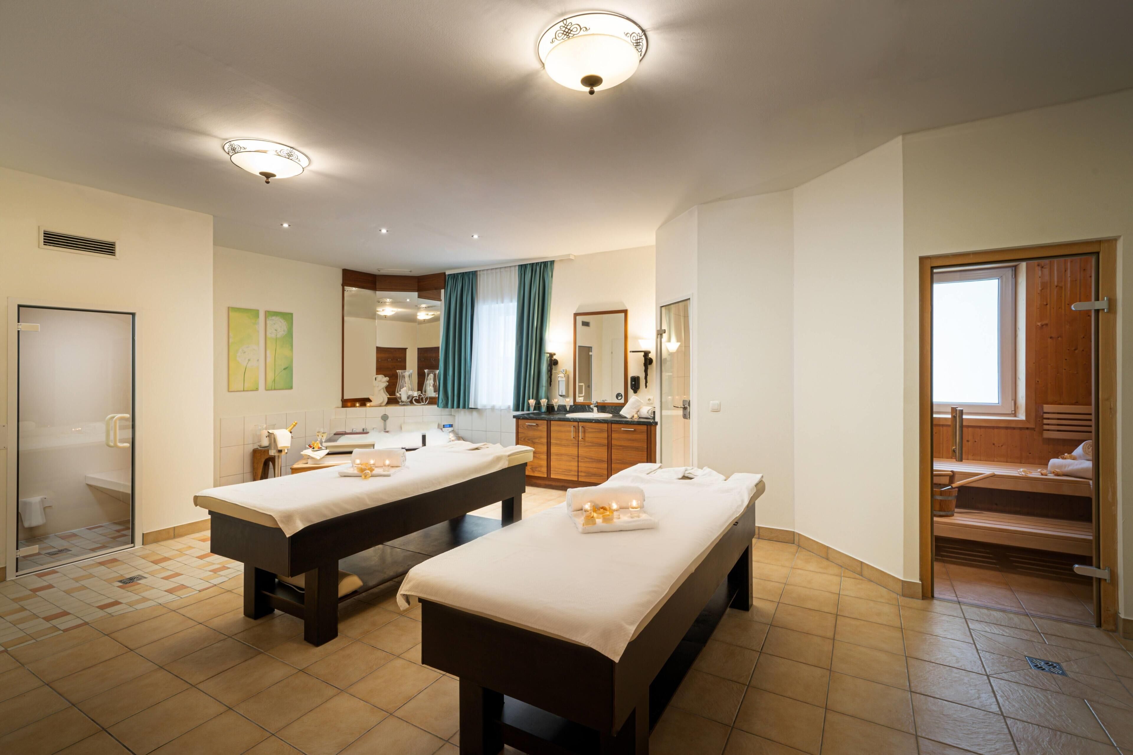 Ein Hotelzimmer mit zwei Betten, einem Badezimmer, einer Dusche und einer Holztreppe.