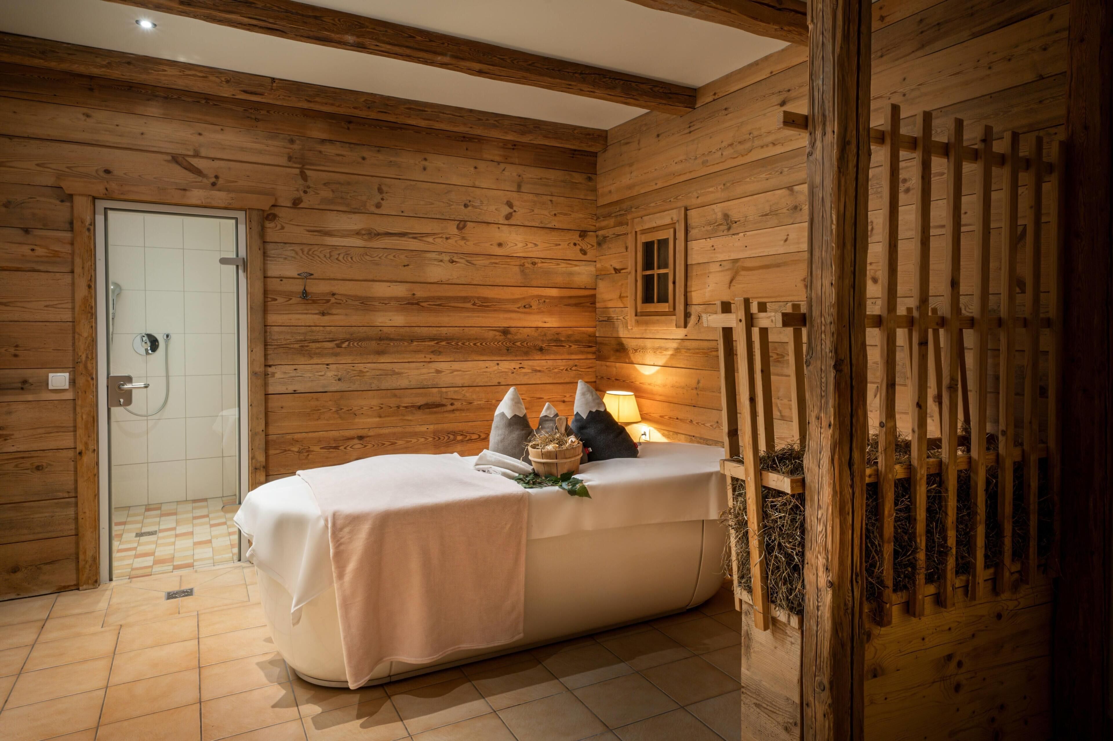 Une pièce en bois avec un lit, une porte et une petite fenêtre.