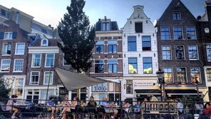 Uma fileira de edifícios em estilo europeu tradicional, com um café ao centro.