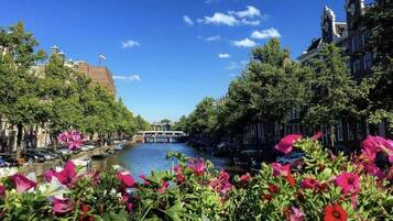 Een gracht met boten, omzoomd door bomen en gebouwen.