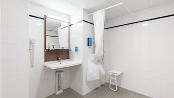 Ein modernes Badezimmer mit einem weißen Waschbecken, einem Spiegel und einer Duschkabine.