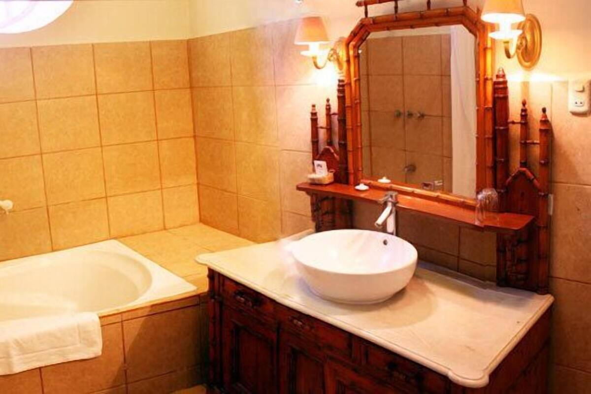 A bathroom with a bathtub, a sink, and a mirror.
