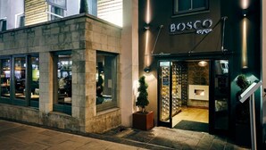 A building with a storefront labeled 'BOSCO lounge' and a potted plant outside. - Hotel Bosco (Surbiton)