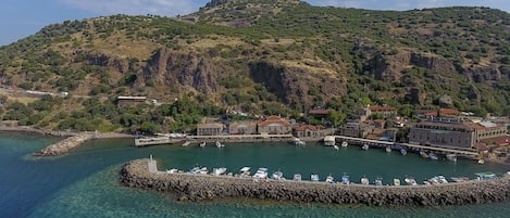 A coastal town with a marina, stone pier, and buildings with traditional architecture.