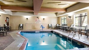 An indoor swimming pool with a no diving sign, pool depth markers, and a lifeguard chair.