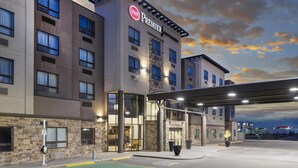 A hotel with a 'Premier' sign, a stone facade, and a covered entrance. - Best Western Premier Freeport Inn Calgary Airport (Calgary)
