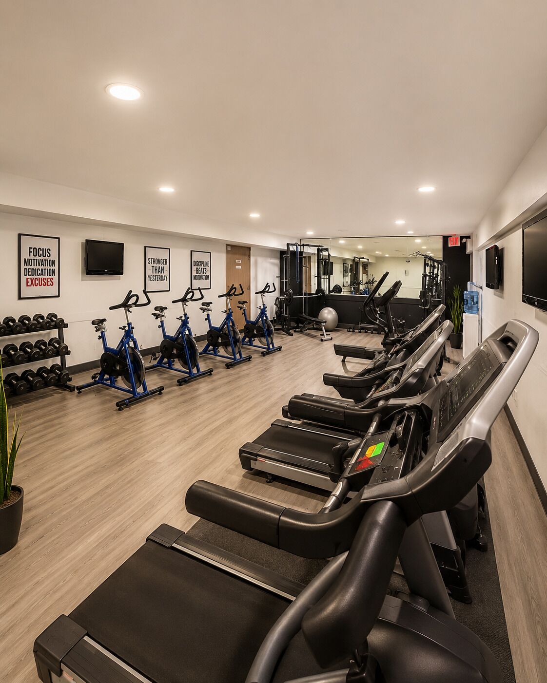 Une salle de sport équipée de tapis de course, de vélos d’appartement et d’appareils de musculation.