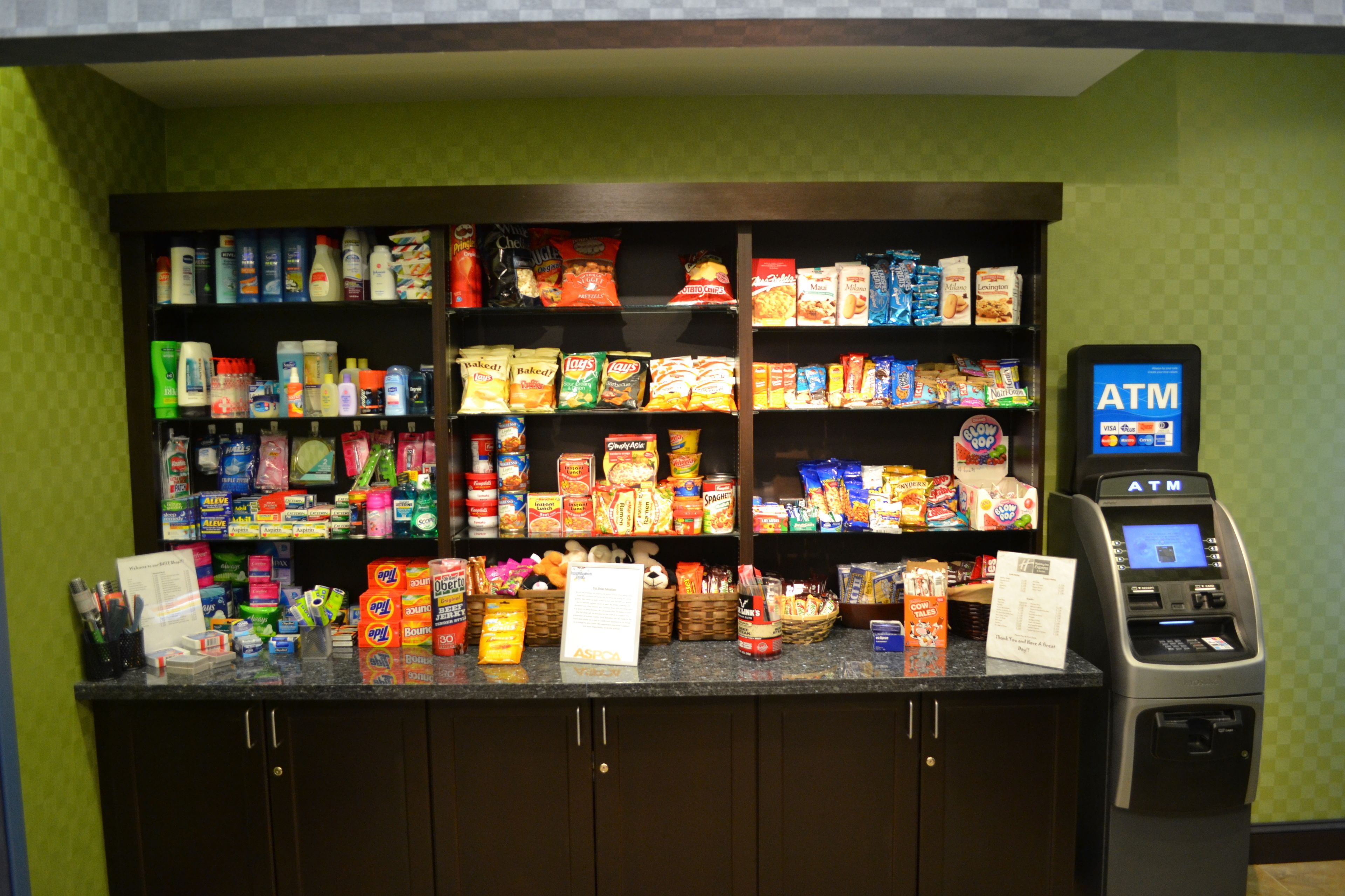 A self-service kiosk with an ATM, stocked with snacks and beverages.