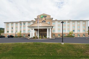 A hotel with a central entrance, multiple floors, and a flagpole with an American flag. - Holiday Inn Express Hotel and Suites Scranton by IHG (Scranton)