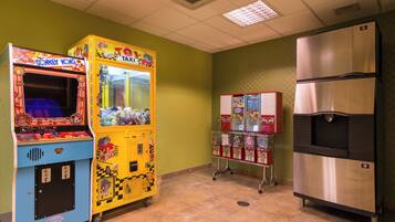 Una habitación con máquina expendedora, refrigerador y piso de baldosas.