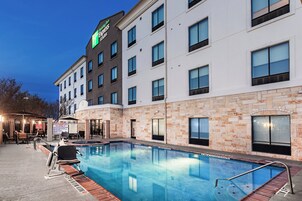 Una piscina al aire libre, tumbonas