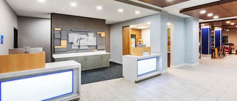 A modern reception area with two reception desks, a wooden ceiling, and a tiled floor.