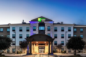 A Holiday Inn Express building with a prominent entrance, multiple windows, and a stone facade.