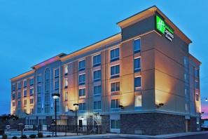 A Holiday Inn Express & Suites building with a brick facade and multiple windows.