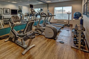 A gym with treadmills, elliptical machines, and free weights.