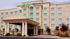 A Holiday Inn Express & Suites hotel with a central entrance, multiple windows, and a brick facade.