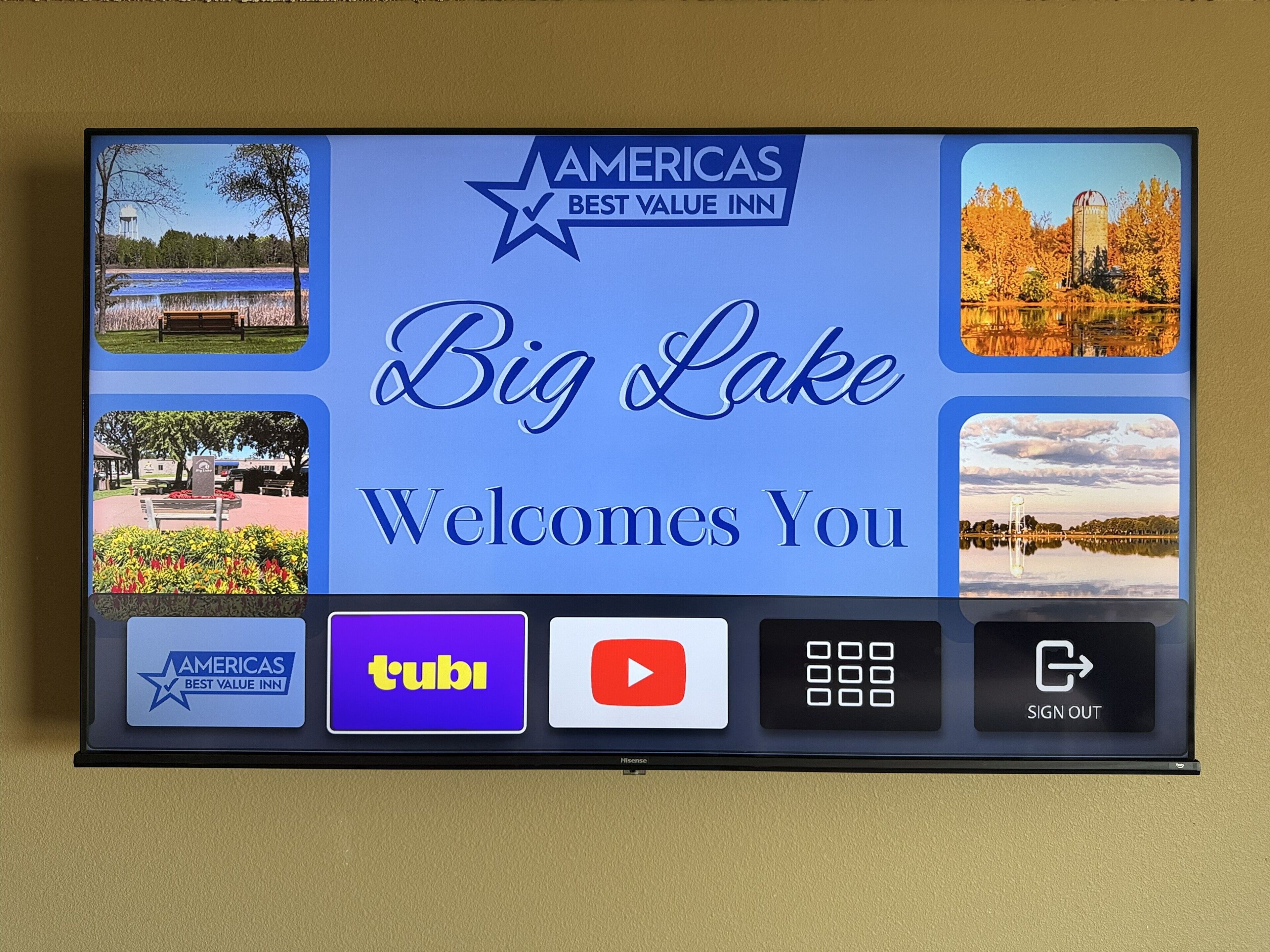 Una pantalla digital con el texto 'Big Lake le da la bienvenida' y varios logotipos, incluyendo 'Americas Best Value Inn' y 'tubi'.