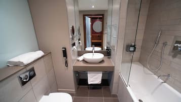 A modern bathroom with a sink, mirror, and shower.