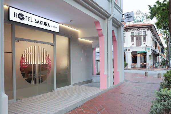 Entrada de un hotel con un letrero que dice 'HOTEL SAKURA by VENUE'.