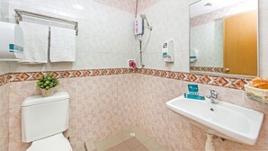 A bathroom with a toilet, sink, shower, and a mirror. - Hotel 81 Lucky (Singapore)