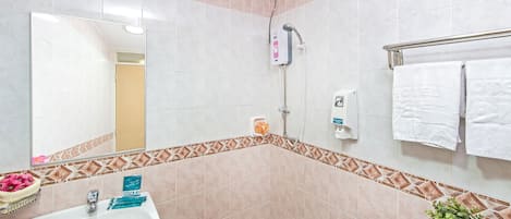 Un baño con lavamanos, espejo, ducha e inodoro.