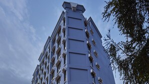 Ein modernes Hotel mit einem gut sichtbaren 'HOTEL 81'-Schild, das einen Hauseingang an einer Ecke, große Fenster und eine Glasfassade aufweist.
