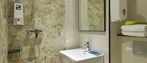 A bathroom with a shower, sink, toilet, and a mirror.