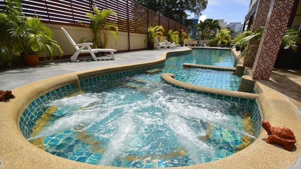 A swimming pool with a hot tub, surrounded by lounge chairs and potted plants. - Mei Zhou Phuket Hotel (Phuket)
