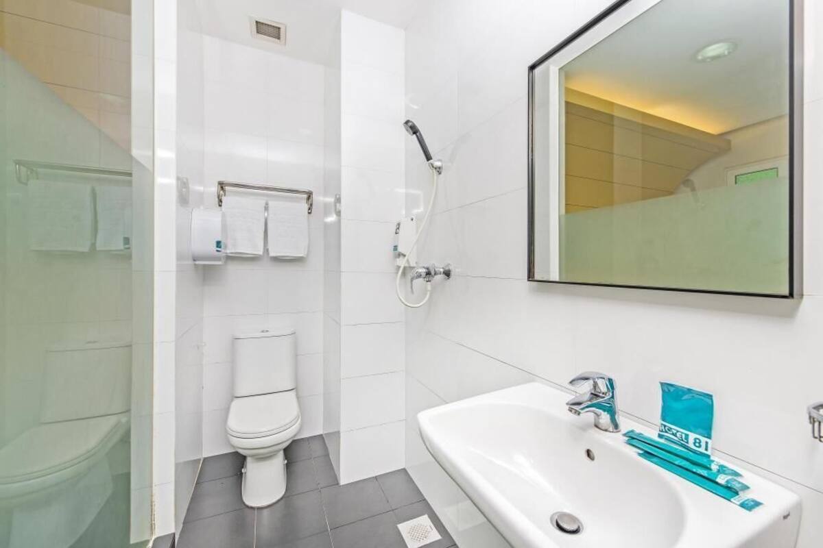 A modern bathroom with a toilet, shower, and sink.