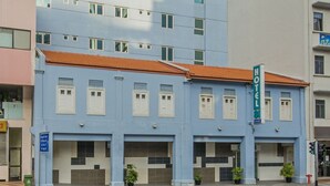 Un hotel con fachada moderna, varios pisos y techo plano.