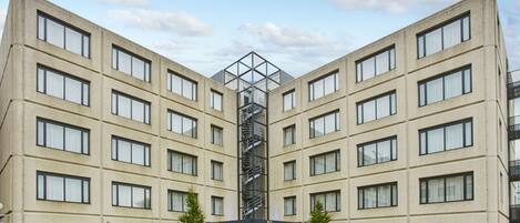 A symmetrical building with a central staircase, multiple windows, and a sign for Holiday Inn Express.
