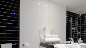 A modern bathroom with a white toilet, a sink, and a mirror. - Holiday Inn Express Amsterdam - Schiphol by IHG (Hoofddorp)