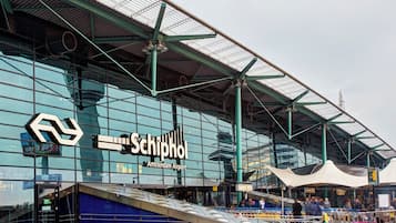 Een modern gebouw met een opvallend bord waarop 'Schiphol Amsterdam Airport' staat.