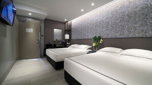 Una habitación de hotel moderna con dos camas, un baño y un televisor.