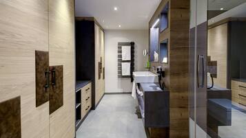 A modern bathroom with a large mirror, a sink, and a shower area.