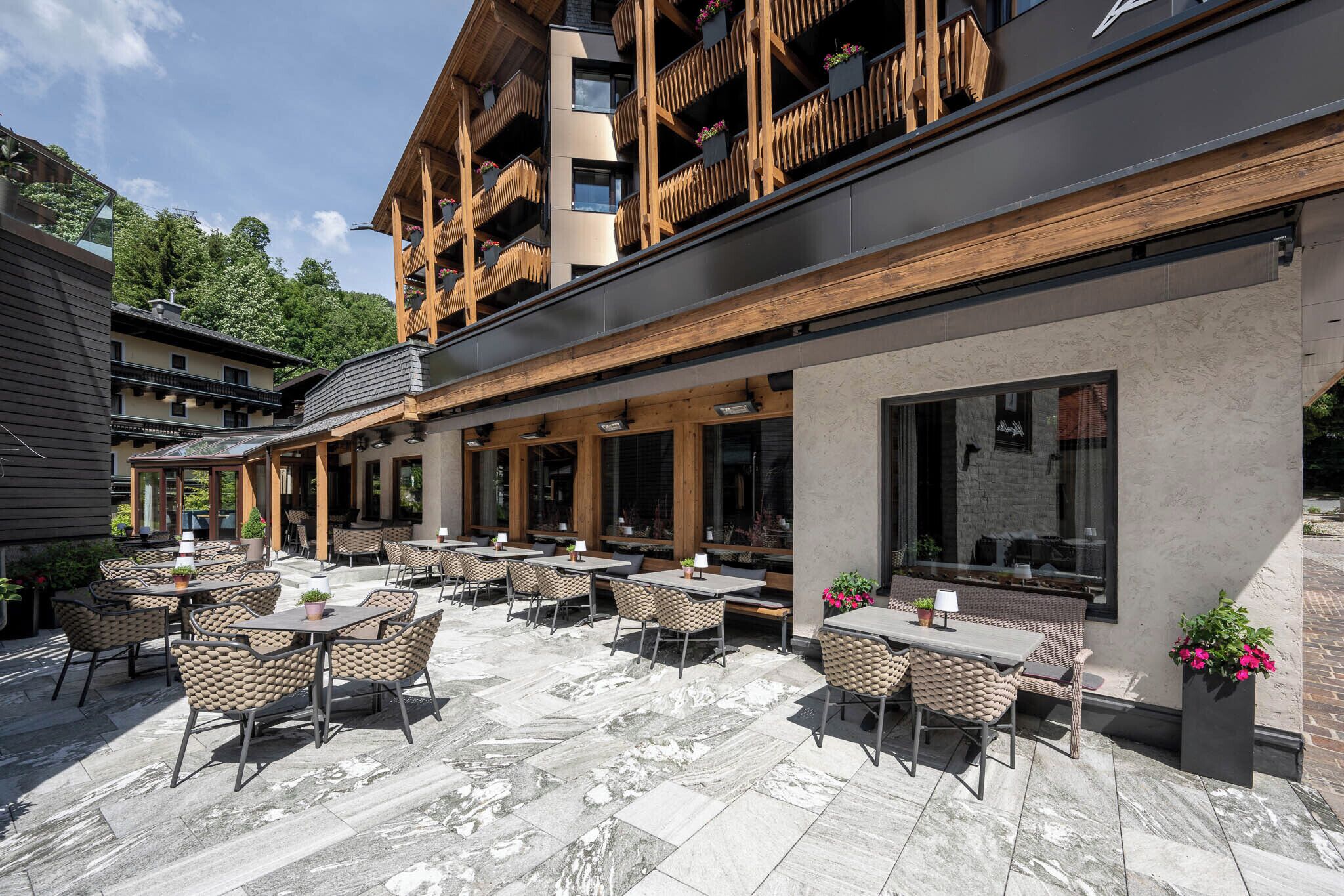 A building with outdoor seating and a balcony with wooden railings.