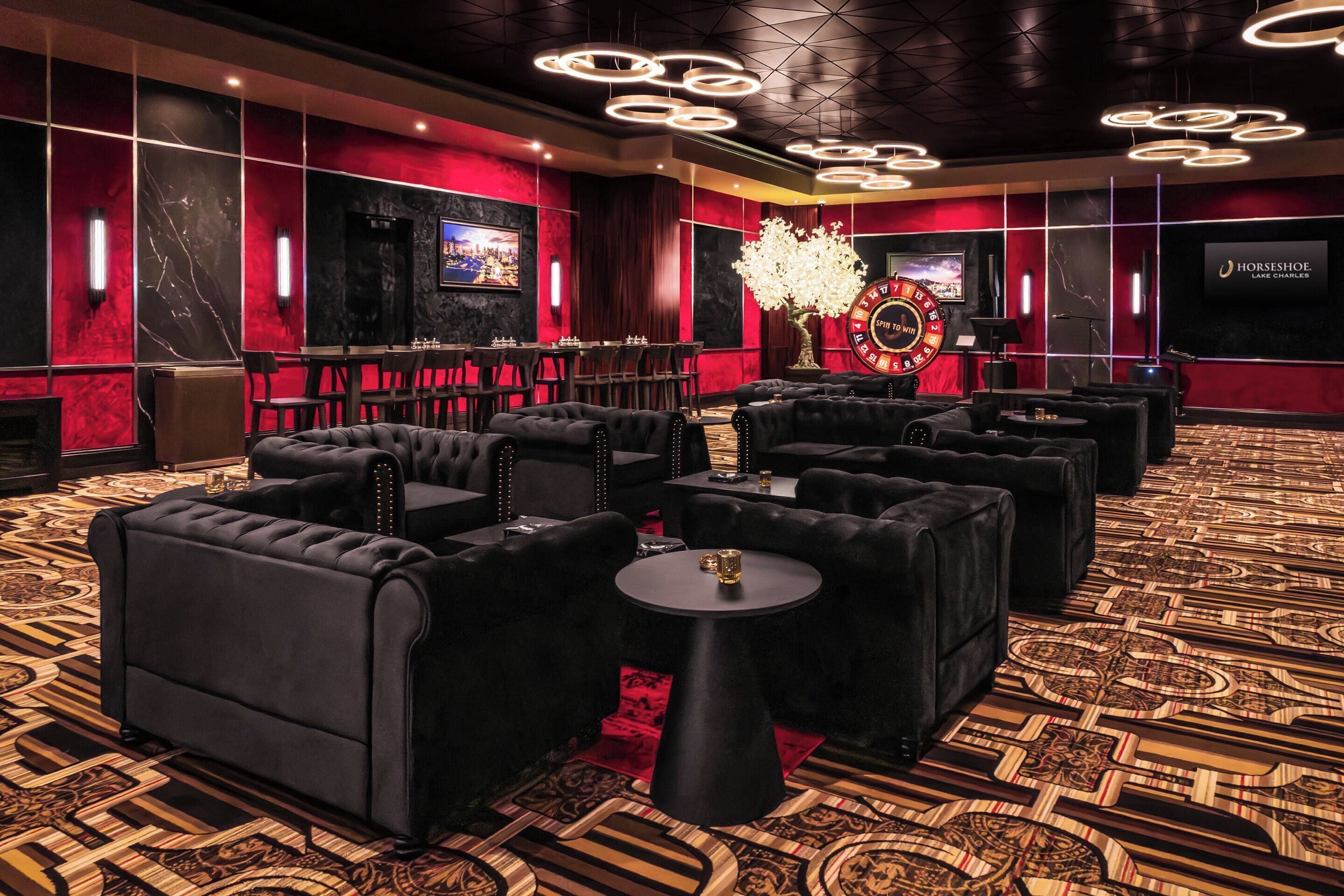 Ein luxuriöser Lounge-Bereich mit bequemen Sitzgelegenheiten, einem großen Kronleuchter und einer auffälligen Hufeisen-Rad-Dekoration.