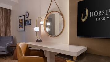A modern room with a desk, a mirror, and a mounted sign.