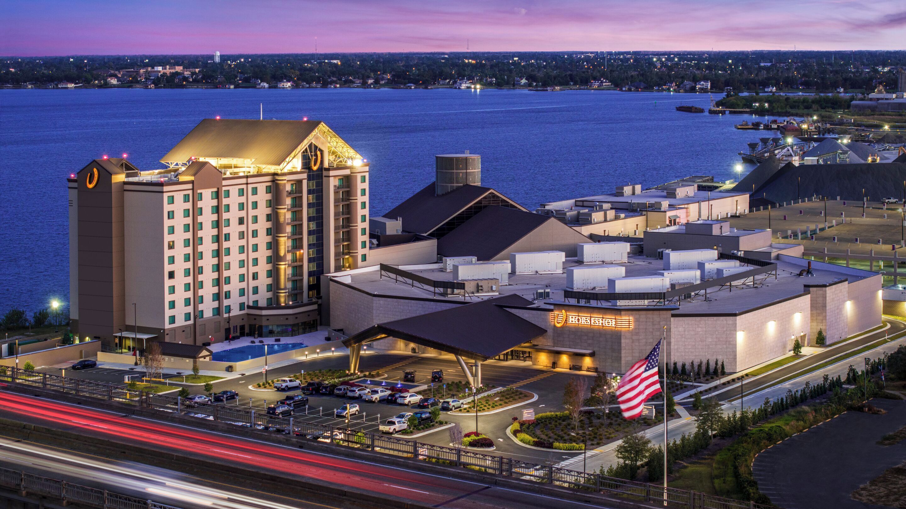 A hotel with a large building, a swimming pool, and a parking lot.