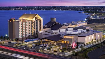 A hotel with a large building, a swimming pool, and a parking lot.